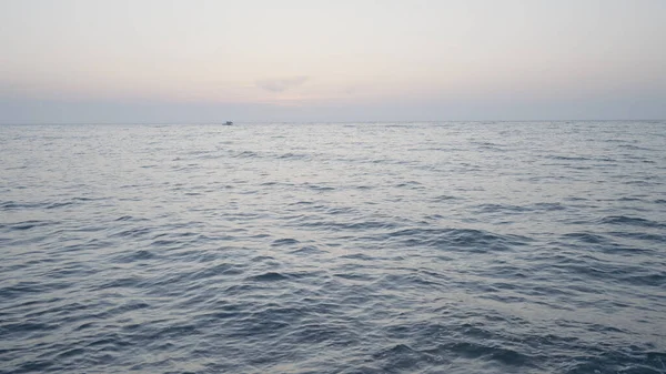 Schöne lange See. Handeln. Das wogende Meer in der Landschaft vor dem Hintergrund eines leicht nebligen Himmels, hinter dem Schiffe in der Ferne segeln. — Stockfoto