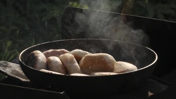 Piknik az utcán. Kreatív. Egy nagy csészealj, amelyen finom hús sült, és füst jön, szeletek készülnek a természetben . — Stock videók