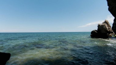 Kayaların ve kumlu deniz kıyısının havadan görünüşü, yaz ve tatil konsepti. Başla. Ufkun ötesindeki uçsuz bucaksız okyanusla taş kemerinde uçuyor..
