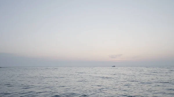 Schöne lange See. Handeln. Das wogende Meer in der Landschaft vor dem Hintergrund eines leicht nebligen Himmels, hinter dem Schiffe in der Ferne segeln. — Stockfoto
