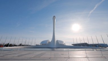 Sochi 'deki Olympic Park' ın merkez meydanı. Başla. Mavi gökyüzü arka planında, parlayan güneşli sıradışı bir heykeli olan yaz manzarası..