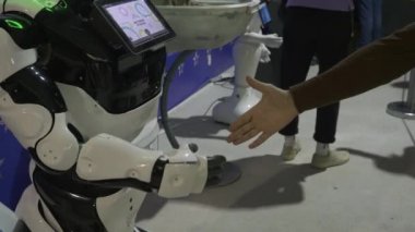 Sayborgu selamlayan adama yakın çekim. HDR. İnsanlarla etkileşim kuran gelişmiş cyborgları göstermek. Robotik ve Sibernetik