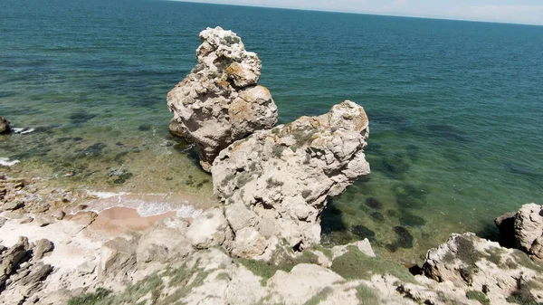 Vista al mar situada junto a las montañas.Acción. Drone vista de un hermoso paisaje marino en grandes rocas cerca del mar y las colinas altas. — Foto de Stock