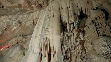 Işıklı mağaranın içinde. Başla. Dağların içindeki taş mağaraların şaşırtıcı doğası. Mağara müzelerine gezintiler. Mağaradaki doğal taş sütunlar