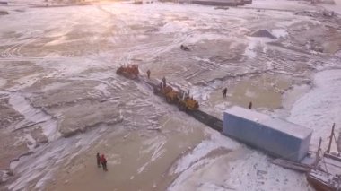 Mavna boşaltma işleminin hava görüntüsü. Şarjör. Bir traktörle kargo gemisinden büyük bir konteynır taşıyorum..