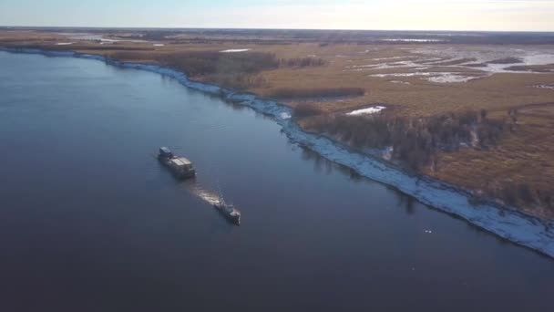 Vista aérea de una barcaza flotando en un amplio río más allá de los prados de otoño. Clip. El buque de carga que transporta mercancías en un río navegable. — Vídeo de stock