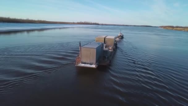Barge porte-conteneurs naviguant sur une large belle rivière sur fond de ciel couchant. Clip. Concept de transport, vue aérienne. — Video