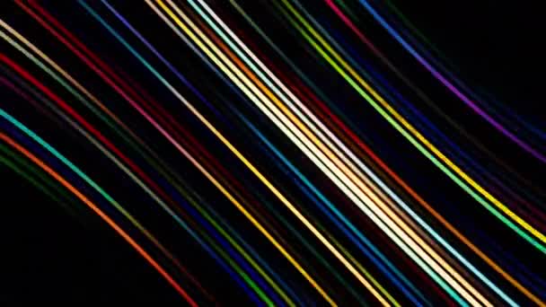 Las líneas diagonales del arco iris brillan sobre fondo negro. Moción. Hermosas líneas de arco iris brillan como en la discoteca. Líneas brillantes multicolores para discoteca — Vídeo de stock