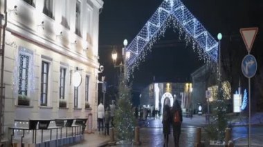 Yeni yıl ve Noel için güzel dekore edilmiş şehir meydanı. Başla. Gece şehrinin süslü caddelerinde ve meydanlarında yürüyen insanlar ve turistler.
