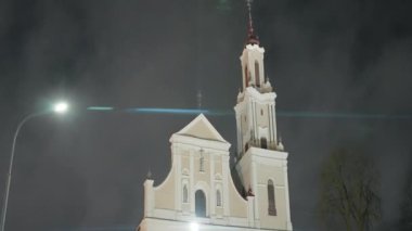 Gece şehrindeki eski Katolik Kilisesi. Başla. Geceleri aydınlatılmış güzel bir ışık tapınağı. Modern şehirde kulesi olan Katolik kilisesi.