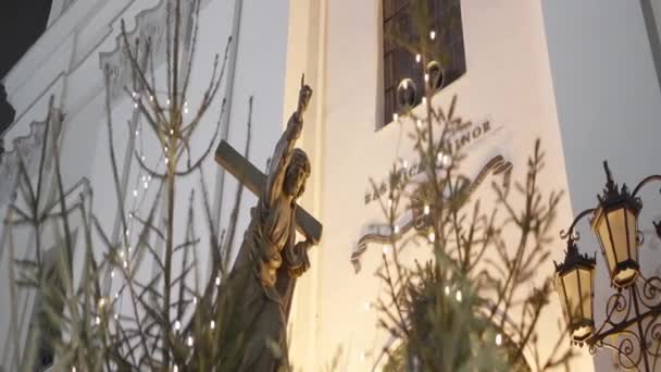 Нижний вид на здание церкви, крест и дерево с гирляндой. Начали. Концепция религиозных праздников. — стоковое видео