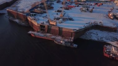 Kışın deniz gemilerinin yüklenmesinin en üst görüntüsü. Şarjör. Büyük konteynırların deniz gemilerine yüklendiği yer. Deniz nakliye limanının kış manzarası