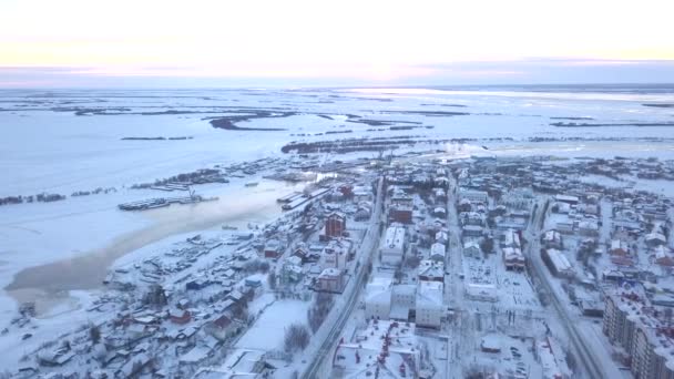 Górny widok miasta na tle pól w zimie. Klip. Piękny zimowy krajobraz miasta z białymi polami w pochmurny dzień. Śnieżne białe pola i miasto — Wideo stockowe
