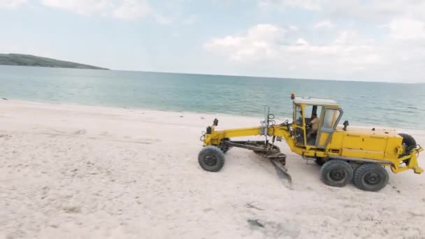 Transporte amarillo en la playa. Acción. Vista de thw drone. Maravilloso paisaje de costa. Gran playa contra el cielo azul — Vídeos de Stock