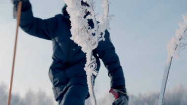 Çocuk kışın sopalarla yürüyor. Yaratıcı. Çocuk kışın İskandinav çubuklarıyla yürüyor. Kış sporları güneşli bir günde yürür