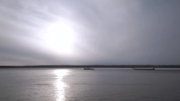 Naturlandskap med en flod i början av vintern och det kalla solljuset reflekteras i vattenytan Clip. Skog växer långt i fjärran och lugnt vatten. — Stockvideo