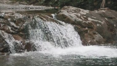 Dağlık bölgedeki nehirde güzel bir şelale. Yaratıcı. Sakin küçük şelale ve soğuk akarsu