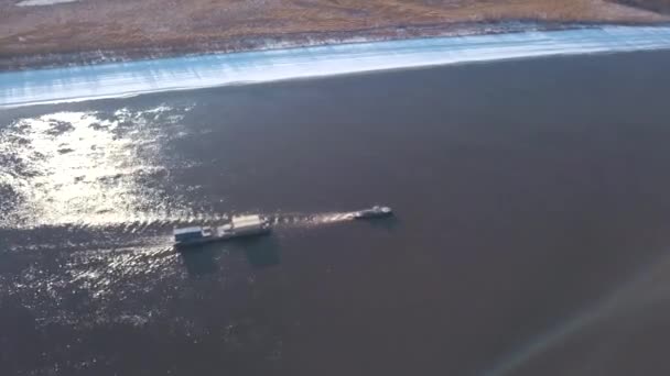 Winter aus der Vogelperspektive. Clip. Frachtschiffe, die den Fluss entlang fahren und Fracht transportieren . — Stockvideo