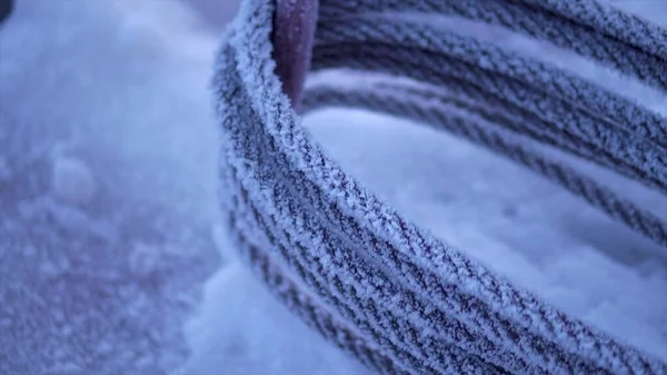 Zblízka zamrzlý kovový kabel pokrytý sněhem. Klip. Průmyslové zázemí, koncepce zimních prací na staveništi. — Stock fotografie