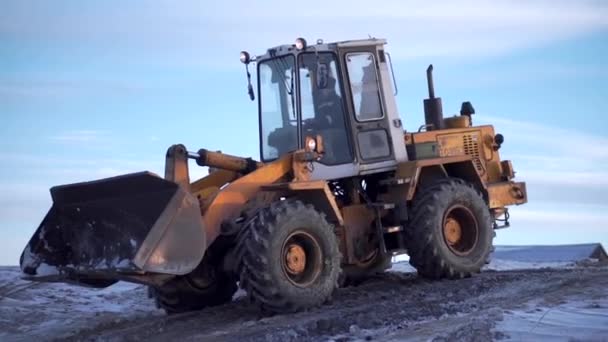 Météo enneigée, excavatrice creusant un sol gelé. Clip. Concept d'industrie lourde, machine au travail de mine sur fond de ciel bleu. — Video