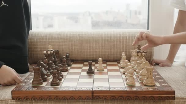 Šachová partie. Kreativní. Šachovnice s bílými a černými figurkami a dvěma lidmi hrajícími. — Stock video