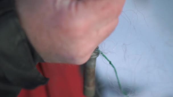 Erkek el oltayı tutuyor. Klips. Güçlü erkek ellerinin, üzerinde uzun bir kablo bulunan balık tutmak için tasarlanmış bir kancayı tutuşu. — Stok video