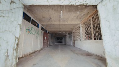 Eski bir bina. Aksiyon. Duvarlarında ve pencerelerinde artık yanıp sönen ışıklar olmayan grafikler olan bir bina..