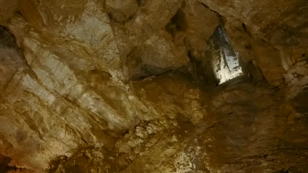 Visa insidan av underjordisk grotta, begreppet äventyr och speleologi. Börja. Stenar och solsken inne i en grotta. — Stockvideo