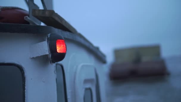 Latarka na statku morskim. Klip. Zbliżenie czerwonej latarni na łodzi w pochmurną pogodę. Transport barki na statku rybackim — Wideo stockowe