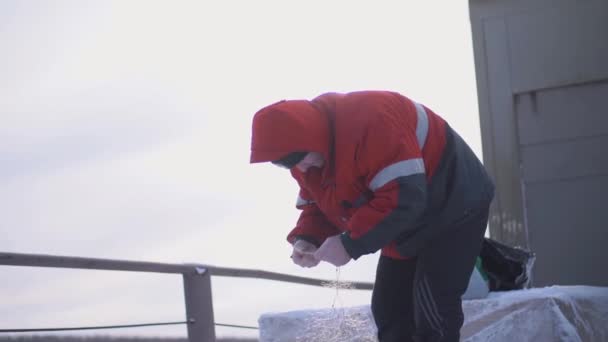 Il pescatore in barca disfa le reti. Clip. Pescatore professionista sulla nave districare manualmente le reti. Pesca invernale in barca — Video Stock
