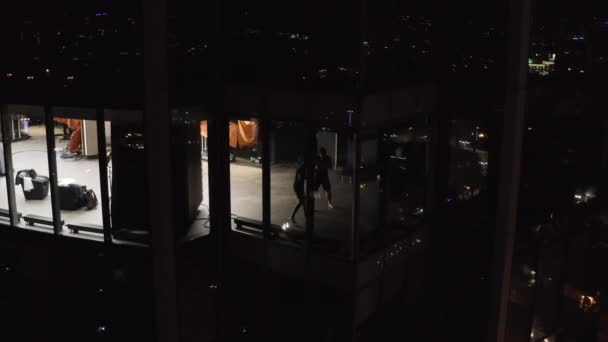 Boxer trainieren nachts im Fitnessstudio. Archivmaterial. Draufsicht auf gläsernen Wolkenkratzer mit beleuchtetem Zimmer in der Nacht. Kinematischer Blick auf Boxer in Halle des nächtlichen Wolkenkratzers — Stockvideo