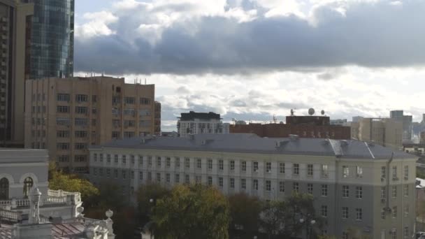A vista do drone. Vista do centro de Ecaterimburgo. Imagens de stock. Céu sombrio sobre a cidade com enormes edifícios ao lado do edifício mais alto com o nome Vysotsky no centro do — Vídeo de Stock