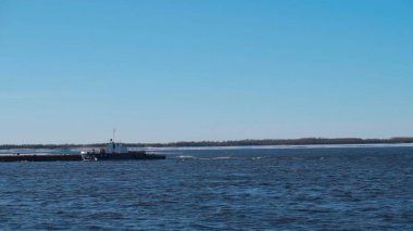 Gemili karlı bir deniz. Clip. Kargo taşıyan büyük gemiler karlı denizde ilerler ve ormanın arkasında görünür bir yer vardır..