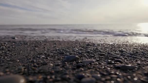 Praia. Acção. Belas ondas do mar correndo ao longo da pedra e você pode ver a espuma do mar e no fundo você pode ver a luz do sol. — Vídeo de Stock