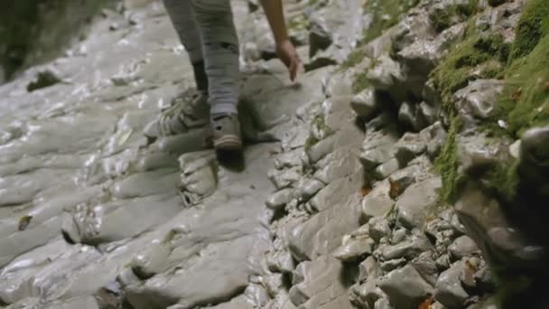 Le touriste grimpe le chemin de pierre. Créatif. Vue du bas vers le haut des jambes d'un touriste qui grimpe la crête de pierre. Jambes d'une fille en pantalon et chaussures montant — Video