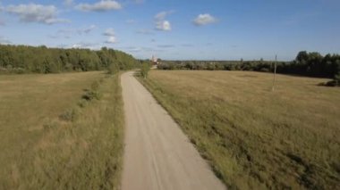 Yeşil alan. Stok görüntüleri. Yolun hemen yanında kuru çimenler olan büyük tarlalar mavi gökyüzüne karşı şehri ve sanayi bölgesini görebilirsiniz..