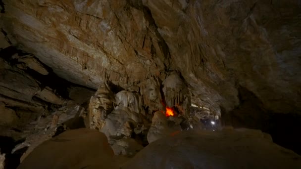 Grutas turísticas em rochas. Acção. Grandes cavernas rochosas com trilhas para caminhadas. Dentro de grande caverna rochosa no escuro — Vídeo de Stock