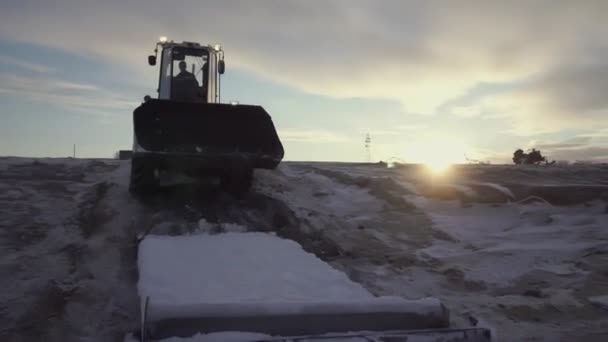 Grote tractor op de noordpool. Een CLIP. Op de voorgrond trekt een trekker een zware lading. In de video, mensen lopen en tractoren werken op een ijzige ruimte — Stockvideo