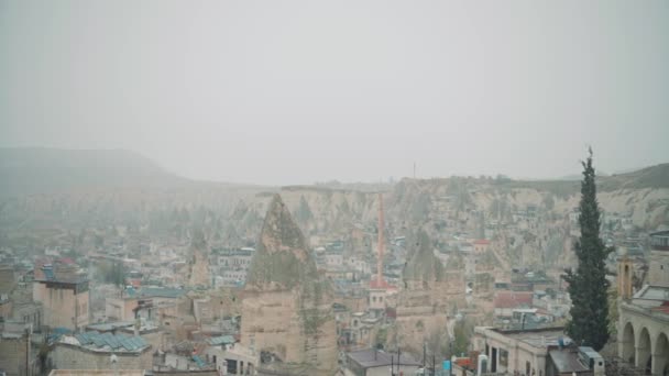 Vista aérea de la antigua ciudad de Capadocia en una neblina matutina. Acción. Antiguas formaciones rocosas y edificios de una hermosa ciudad. — Vídeo de stock