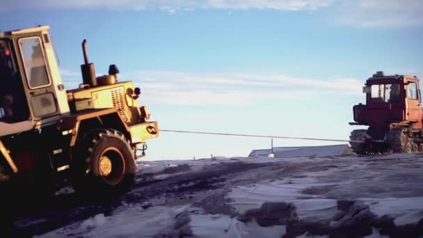 ゲルマン,ベルリン - MARCH 17, 2022: 北極の大きなトラクター. クリップ。 前景ではトラクターが重い荷物を引っ張っている. ビデオでは,人々はアイシー空間で歩き,トラクターは働きます — ストック動画