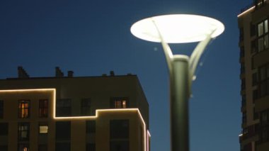 Şehir avlusunu koyu mavi arka planda sokak lambasıyla kapatın. Stok görüntüleri. Gece yarısı bir apartman dairesi olan açık hava manzarası..