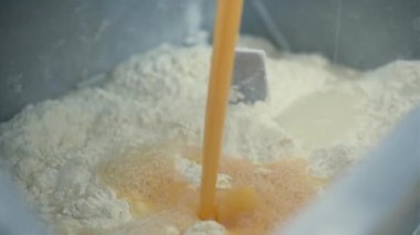 Üretim fabrikada. Klip. Yumurtanın sarısı özel makineler kullanılarak un ve toprakla karıştırılır..