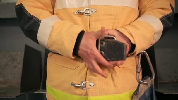 Un pompier de sexe masculin. Un homme en uniforme jaune qui attache soigneusement sa ceinture et serre sa veste. — Video