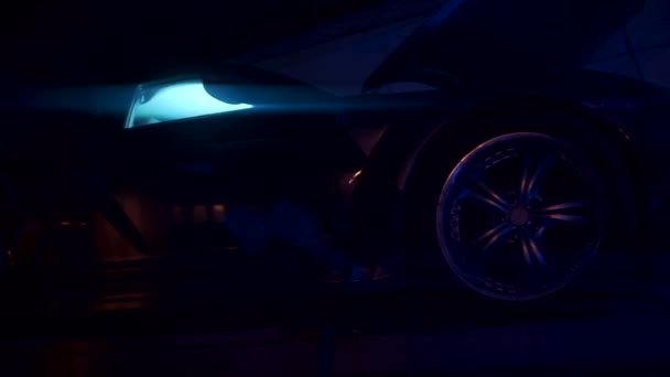 Ein neonbeleuchtetes Auto. Clip.A helles schwarzes Auto mit Neon-Farbe herum und lila Scheinwerfer, die Farbe ändern. — Stockvideo