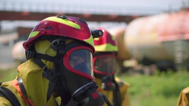 Feuerwehrleute. Clip. Zwei maskierte Männer, die mit einem Schlauch und Wasser Übungen mit speziellen Geräten und in einer speziellen Uniform durchführen. — Stockvideo