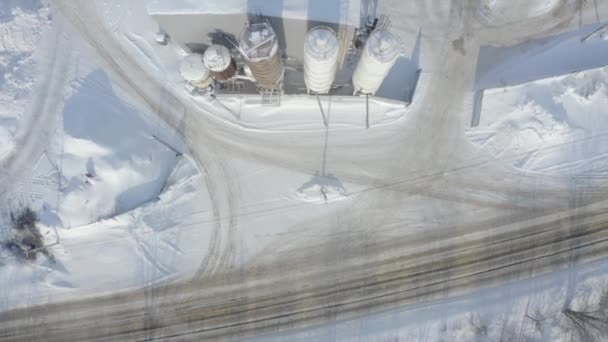 Kış helikopteri manzarası. Şarjör. Fabrikaların, yol ve arabaların yakınında büyük kar yığınları var.. — Stok video