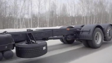 Rusya, MOSCOW - 21 Mart 2022: büyük beyaz bir kamyon yol boyunca ilerliyor. Sahne. Siyah tekerlekler Kamaz 'a yakın çekim. Beyaz kamyon kışın yola çıkar. Çerçevede bir sürü kamyon tekerleği var.