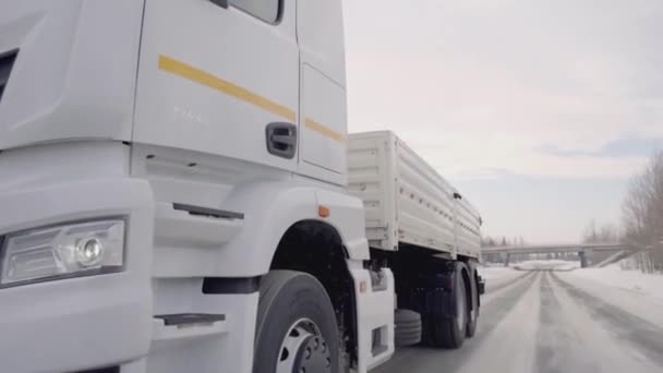 Rusya, MOSCOW - 21 Mart 2022: büyük beyaz bir kamyon yol boyunca ilerliyor. Sahne. Siyah tekerlekler Kamaz 'a yakın çekim. Beyaz kamyon kışın yola çıkar. Çerçevede bir sürü kamyon tekerleği var. — Stok video