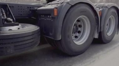 Rusya, MOSCOW - 21 Mart 2022: büyük beyaz bir kamyon yol boyunca ilerliyor. Sahne. Siyah tekerlekler Kamaz 'a yakın çekim. Beyaz kamyon kışın yola çıkar. Çerçevede bir sürü kamyon tekerleği var.