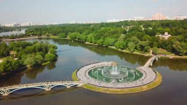 Kuşbakışı manzara. Yaratıcı. Bir anıtı, bir yaz ormanını, bir köprüyü, yeşil yapraklı güzel yaz ağaçlarını ve külleri olan bir yolu görebileceğiniz yükseklikten güzel bir yaz manzarası.